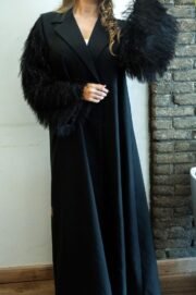 Abaya with wide sleeves, luxurious black clutch decorated with shiny fringes