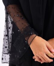 تفاصيل أكمام دانتيل فرنسي على عباية كلوش سوداء