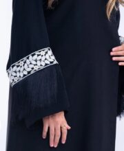 تفاصيل أهداب حريرية متحركة على أكمام عباية سوداء